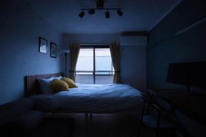 a blue bedroom with a bed and a window at UPHouse 2C Gotokuji in Tokyo +5 photos