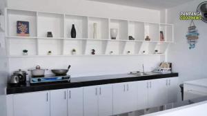 a kitchen with white cabinets and a counter top at Tatz Pool Villa in Anunas