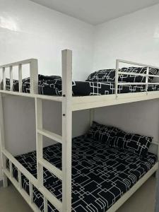 two bunk beds in a white room with a bed at Tatz Pool Villa in Anunas