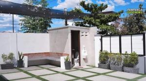 a white building with a black door and some plants at Tatz Pool Villa in Anunas