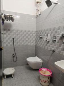 a bathroom with a toilet and a sink at Swastiik Inn in Belpahār