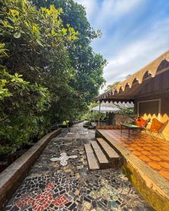 eine Terrasse mit einer Bank und einem Tisch in der Unterkunft Vanaswara in Kolad