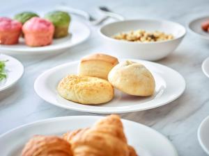 a table with plates of pastries and bowls of food at Park Central Sakura Hotel in Osaka