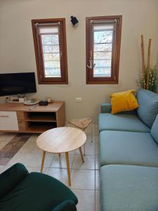 a living room with a blue couch and a table at Beach house IvMare in Ierissos