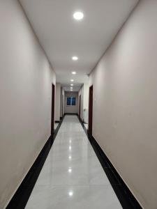 an empty hallway with white walls and a white floor at Swastiik Inn in Belpahār +3 photos