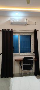 a room with a table and a window with a chair at Swastiik Inn in Belpahār