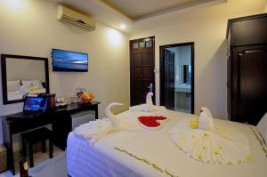 a bedroom with a bed with two swans on it at Full House Hotel in Nha Trang