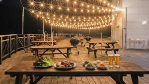 a table with plates of food on it with lights at Gapyeong Laputa Resort in Gapyeong