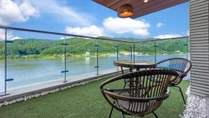 a chair sitting on a balcony with a view of the water at Gapyeong Laputa Resort in Gapyeong +11 photos