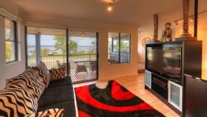 a living room with a couch and a television at Dolphin Waters in Tin Can Bay