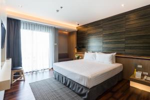 a hotel room with a large bed and a window at Sea Me Spring Tree Hotel in Pattaya