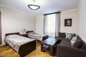 a living room with a couch and a bed and a table at Nick&David INN in Borjomi