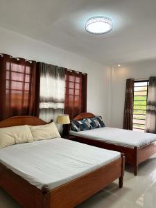 two beds in a room with two windows at Villareal Homestay in Coron