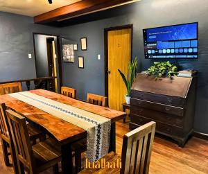 a dining room with a wooden table and a tv at Lualhati Homestay in Baguio