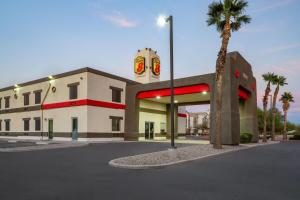 a gas station with a palm tree in front of it at Super 8 by Wyndham Casa Grande in Casa Grande