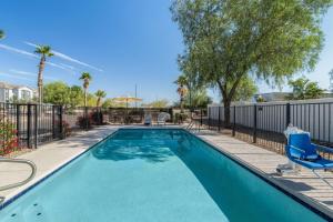 a swimming pool with chairs and trees and a fence at Super 8 by Wyndham Casa Grande in Casa Grande
