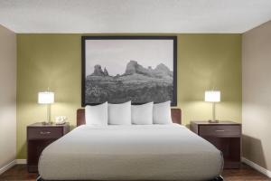 a bedroom with a bed with two lamps and a painting at Super 8 by Wyndham Casa Grande in Casa Grande +41 photos