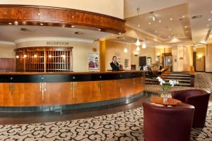 a man standing at a bar in a hotel lobby at Wyndham Garden Berlin Mitte in Berlin