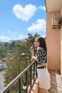 a young girl standing on a balcony looking at the sky at Sun Villa Tam Đảo in Vĩnh Phúc +44 photos