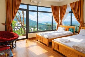 a bedroom with two beds and a large window at Sun Villa Tam Đảo in Vĩnh Phúc