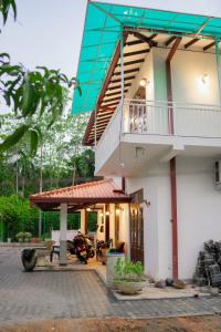 a house with a balcony and a patio at The Leaf Cinnamon villa in Hikkaduwa