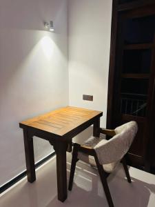 a wooden table and a chair in a room at The Leaf Cinnamon villa in Hikkaduwa +12 photos