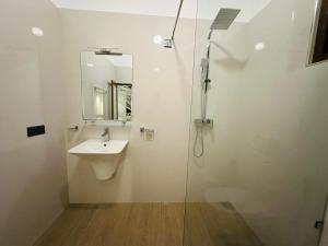 a bathroom with a sink and a glass shower at The Leaf Cinnamon villa in Hikkaduwa
