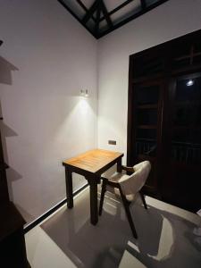 a wooden table and a chair in a room at The Leaf Cinnamon villa in Hikkaduwa
