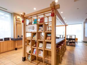 a library with a book shelf and a table at Comfort Hotel Toyokawa in Toyokawa