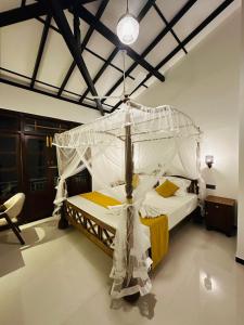 a bedroom with a bed with a canopy at The Leaf Cinnamon villa in Hikkaduwa