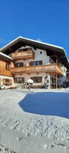 a large building with a snow covered yard in front of it at Gästehaus Annemarie in Reit im Winkl