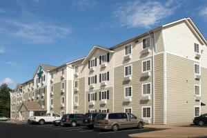 a large apartment building with cars parked in a parking lot at WoodSpring Suites Memphis East I-40 in Memphis