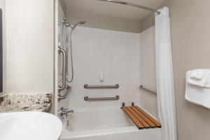 a bathroom with a shower and a toilet and a sink at Days Inn by Wyndham Charleston WV in Charleston