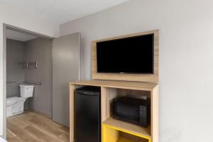 a flat screen tv sitting on top of a entertainment center at Days Inn by Wyndham Charleston WV in Charleston