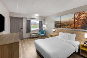 a hotel room with a bed and a television at Days Inn by Wyndham Charleston WV in Charleston