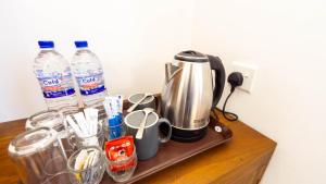 a counter with a coffee maker and two bottles of water at Nimsara Lodge Sigiriya in Sigiriya