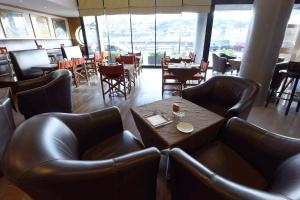 a restaurant with leather chairs and a table with glasses on it at Hotel Le Grand Pavois in Fécamp