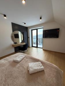 a bedroom with a bed with two white towels on it at Willa Black Wood in Istebna +27 photos