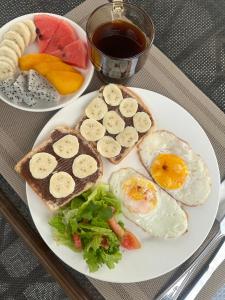 a plate of food with eggs and bread and fruit at La Petite Maison Luang Prabang in Luang Prabang +12 photos