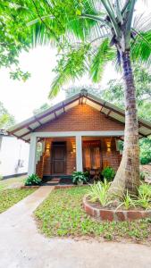 a house with a palm tree in front of it at Nimsara Lodge Sigiriya in Sigiriya