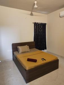 a bed in a room with a brown bed frame at Two Heart heaven in Covelong