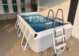 a swimming pool in front of a house at NAFIZ Pool Homestay Melaka - Fully AC 4 Rooms with 3 Toilets, PS4 in Kampong Alor