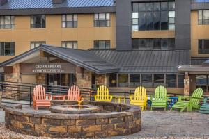 a group of colorful chairs around a fire pit in front of a building at Hilton Vacation Club Cedar Breaks Brian Head in Brian Head