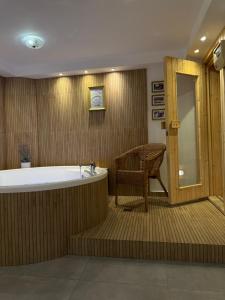 a large bathroom with a tub and a chair at Villavender Boutique Suites in Netivot +31 photos
