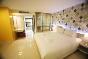 a bedroom with a large white bed in a room at Trebel Pattaya in Pattaya