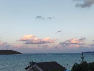 a view of the ocean with a building and a lighthouse at The Seaview Residency in Port Blair +17 photos