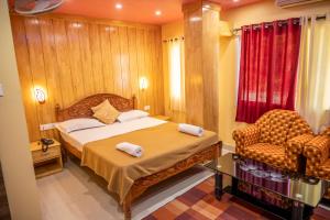 a bedroom with a bed and a chair in it at The Seaview Residency in Port Blair