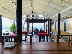 a restaurant with red tables and a view of the ocean at Amadio Beach Resort in Hikkaduwa