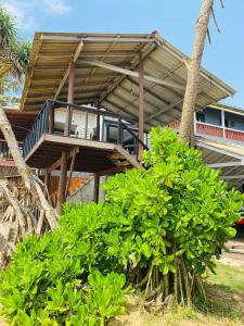 a house with a deck with a balcony at Amadio Beach Resort in Hikkaduwa