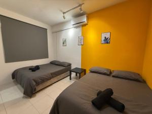 two beds in a room with a large screen at R3troHouse3 4BR 14PAX Near188Tower, HTAA, In Town in Kuantan